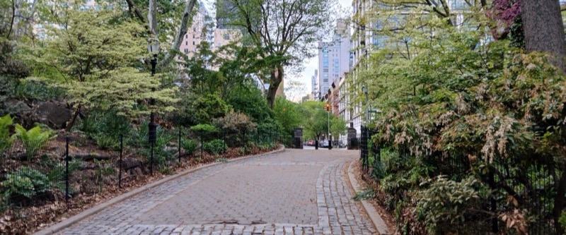 Cobblestone path between planted borders and trees in Carl Schurz Park, Upper East Side, Manhattan