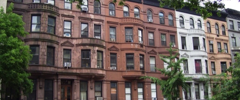 Row of brownstone and brick townhouses with bay windows on West 96th Street, Upper West Side, Manhattan